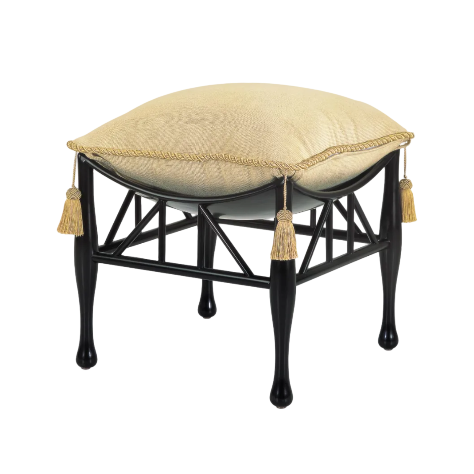 A square ottoman stool with a black metal frame and four tapered legs, featuring a cream-colored cushion with decorative braided trim and hanging tassels, shown on a plain white background.
