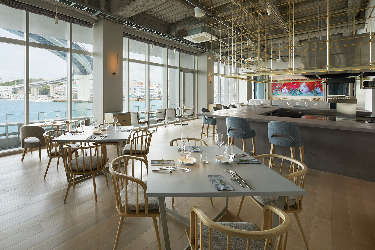 Modern office space with large windows, tables, and chairs.