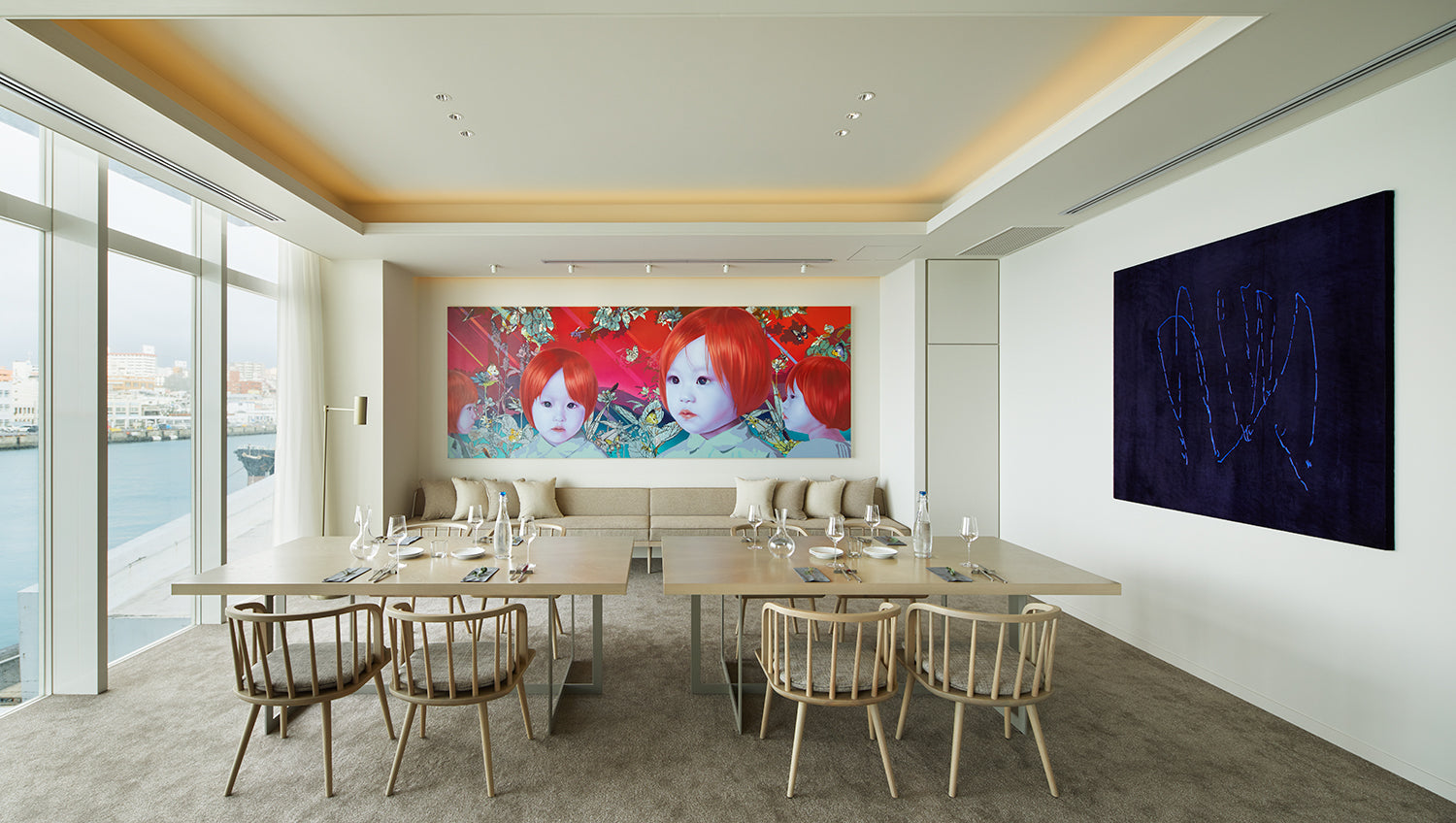 Modern conference room with large wall art and a cityscape view.