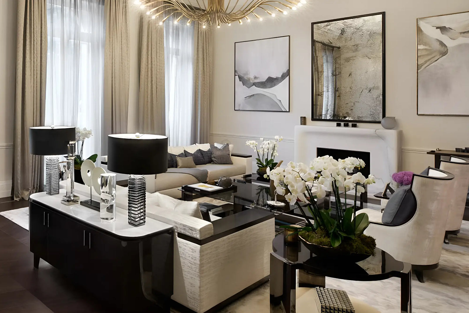 A luxury modern living room featuring a black and white sofa, a black sideboard with white marble tops, a gold chandelier, and elegant wall art.