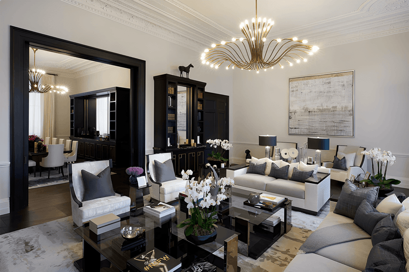 A luxury modern living room featuring a large gold multi-arm chandelier, black and white sofas, marble coffee tables, and elegant home decor.