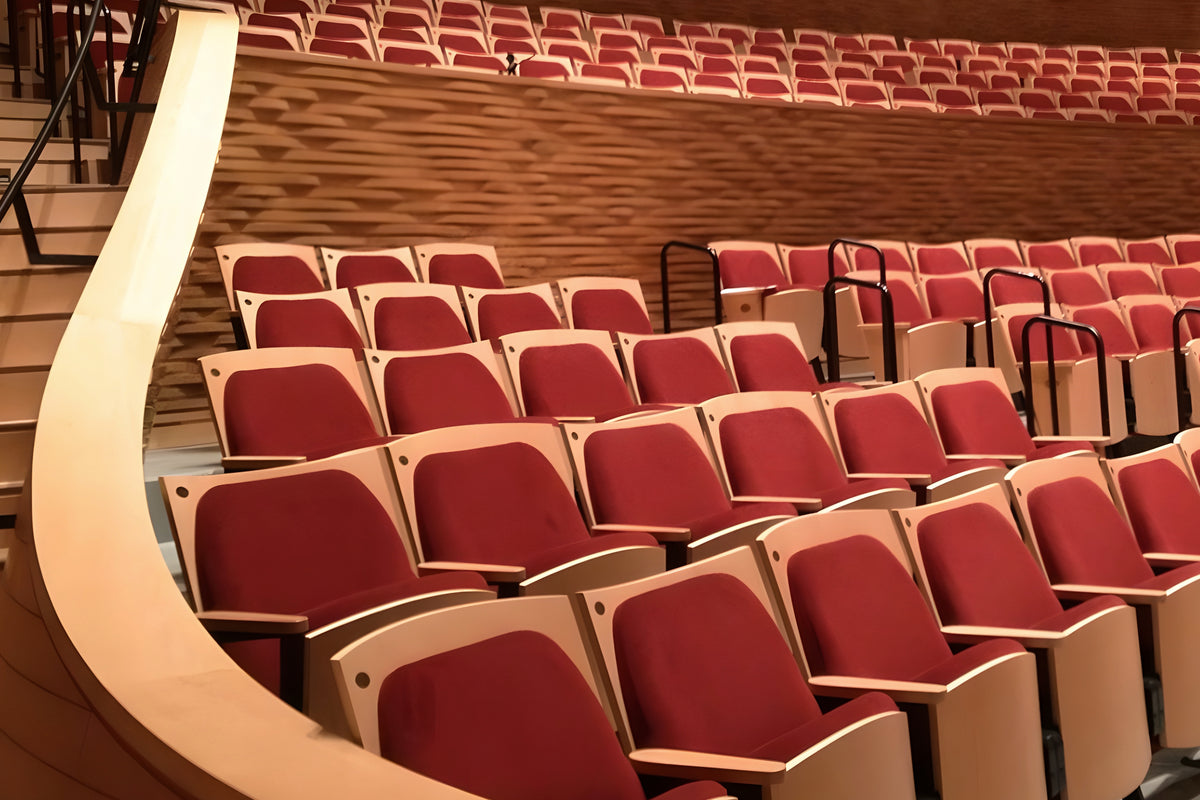 Red theater seats in a row with wooden floor and walls