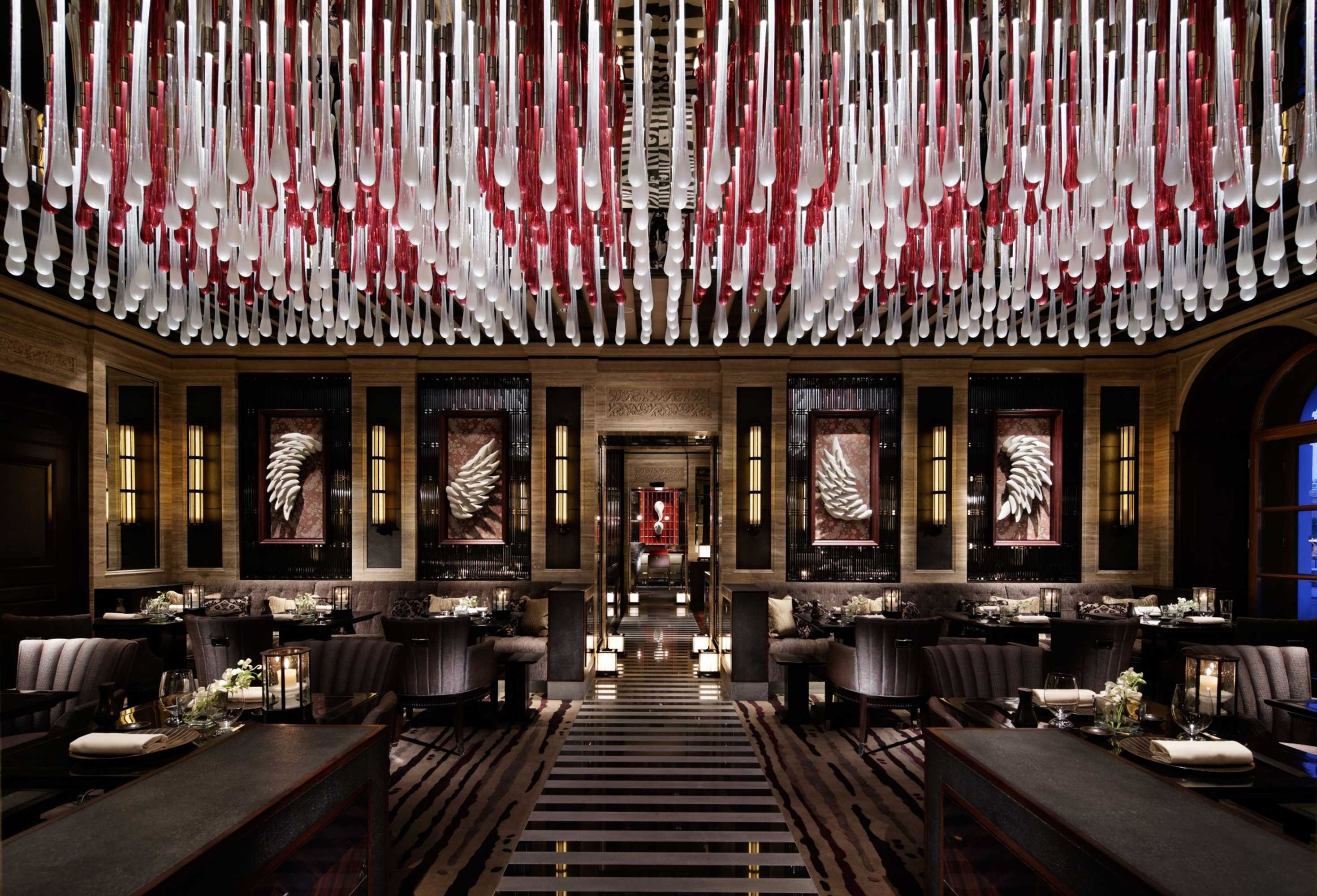 Luxurious restaurant interior with artistic knife and fork ceiling installation.