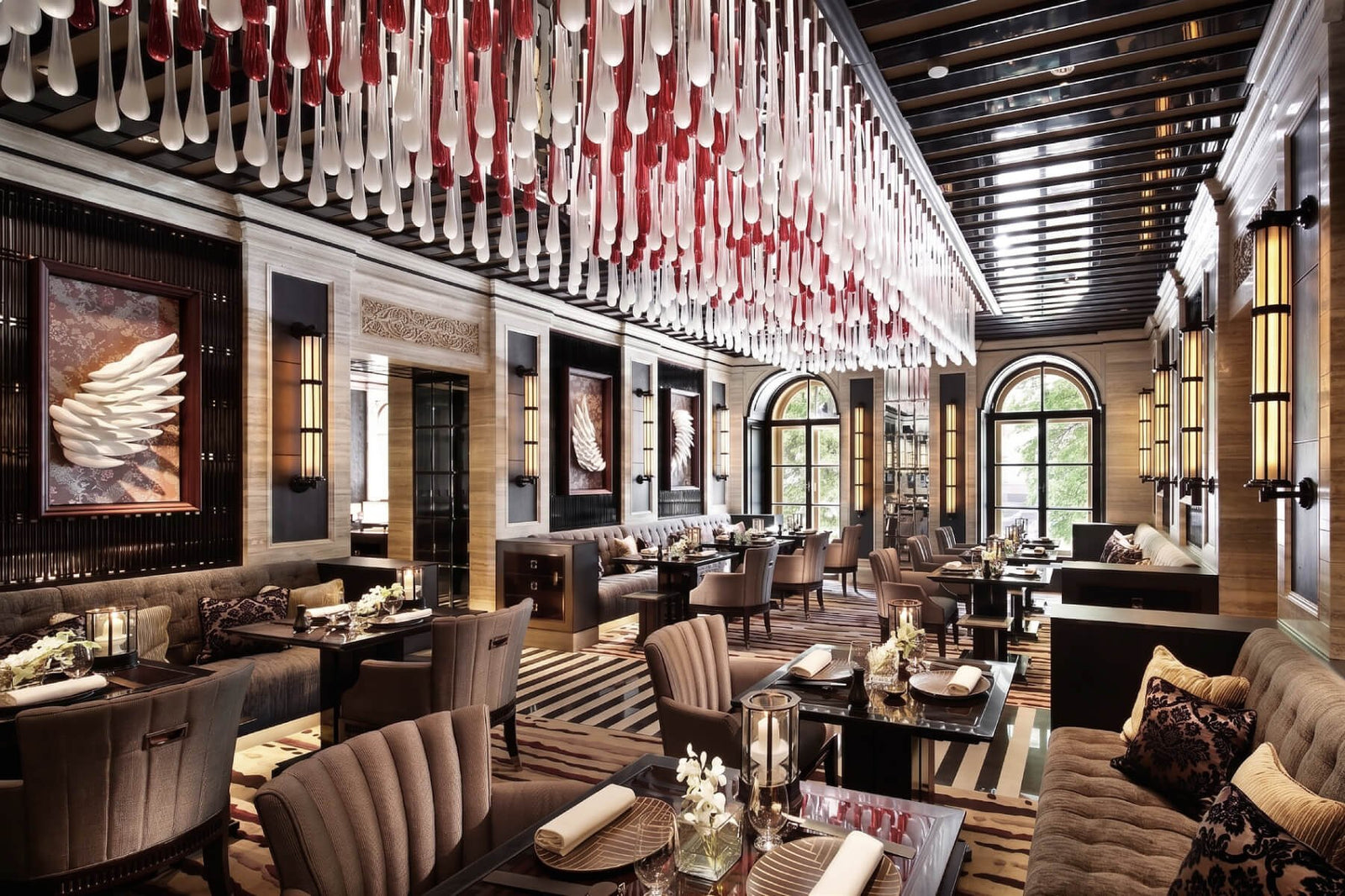 Luxurious restaurant interior with a large chandelier, tables, and chairs.