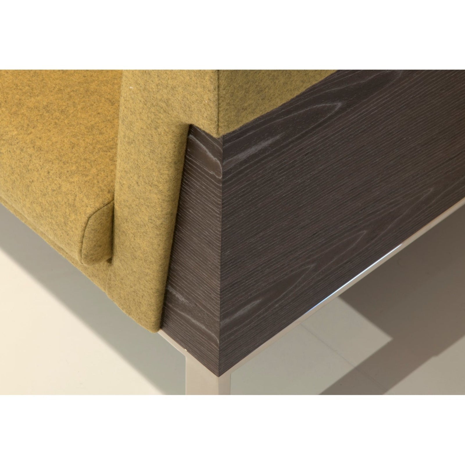 Corner of a piece of furniture with a wooden frame and fabric-covered backrest.