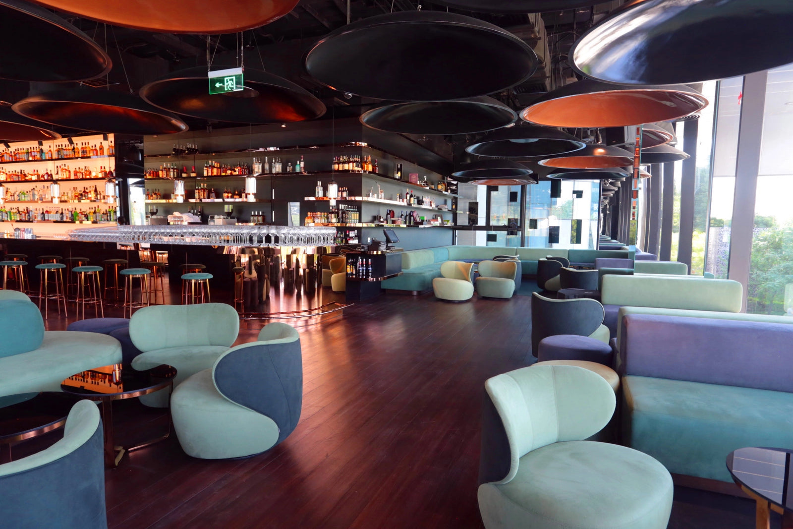 Modern bar and lounge area with colorful furniture and ceiling lights.
