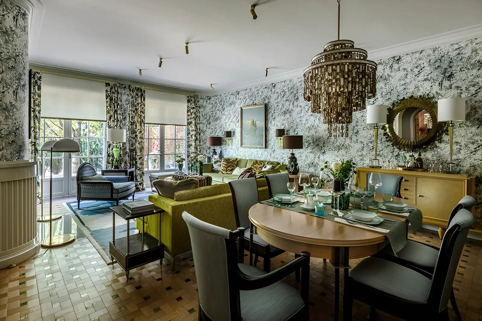Modern living room with a dining table and chairs, decorative elements, and large windows.