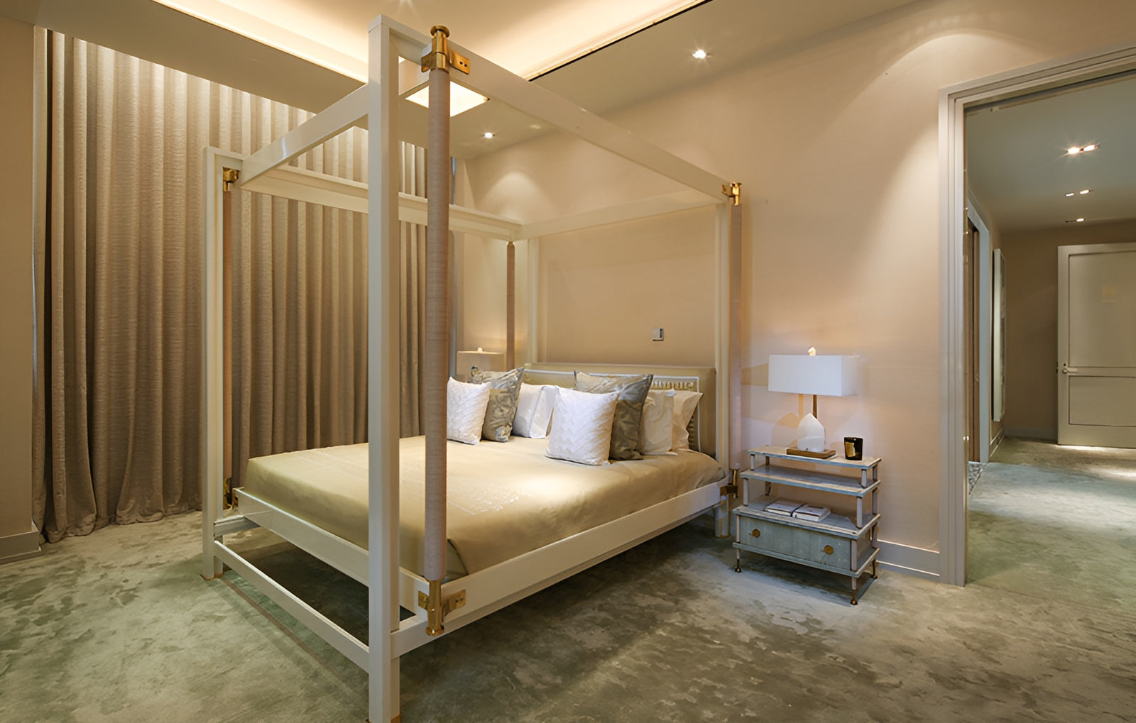 Neatly arranged bedroom with a four-poster bed, nightstands, and a lamp.